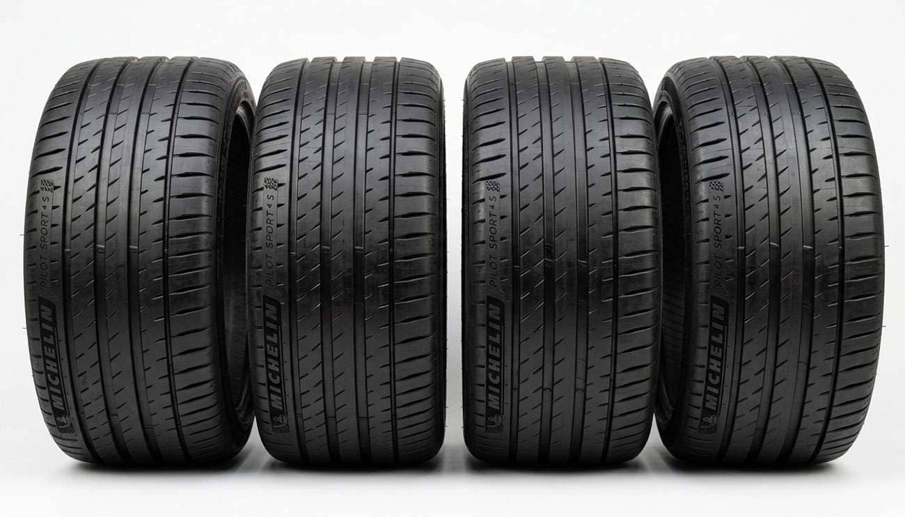 Four low profile 245/40R19 ultra high performance tires standing in a row on a clean white backdrop