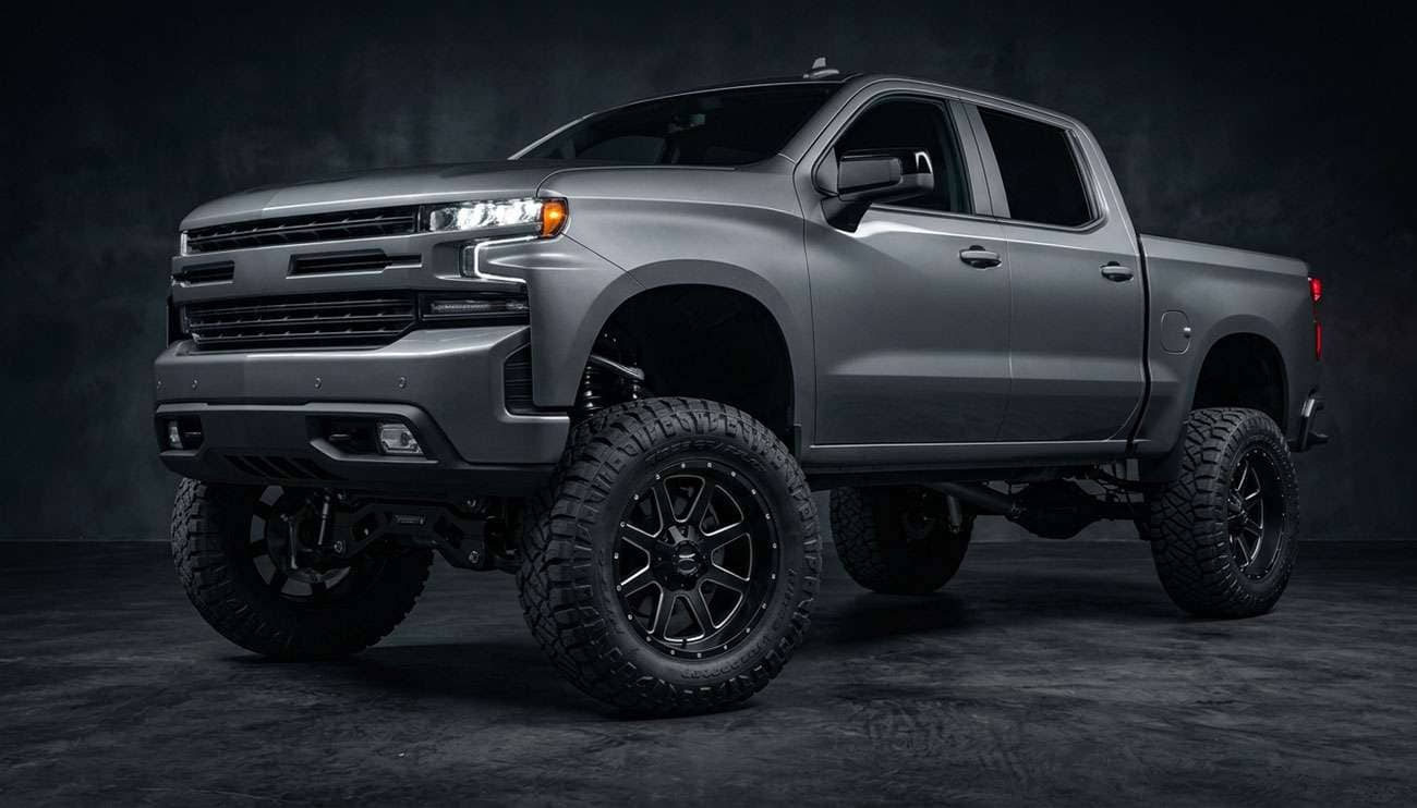 Lifted pickup truck with aggressive aftermarket wheels and oversized off-road tires in shop setting