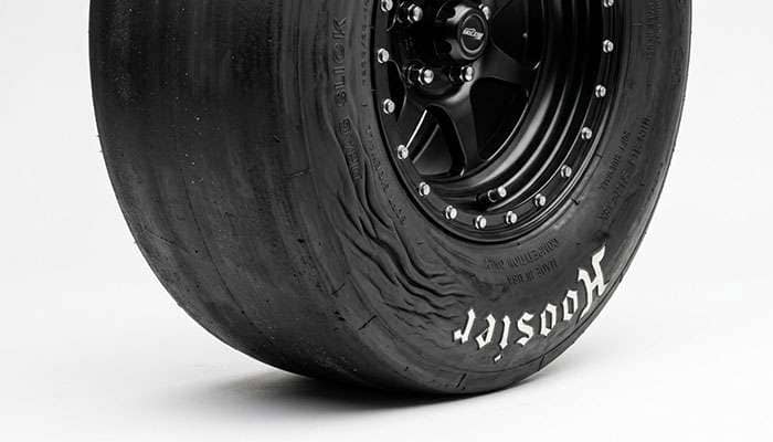 Bias-ply drag slick close-up showing smooth treadless surface and soft wrinkle sidewall
