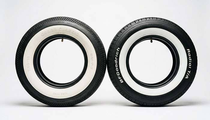 side by side comparison of a bias-ply vintage tire and a modern radial tire in the same classic car size