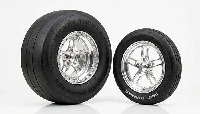 Tall wide rear tire beside a narrow front tire showing a big-and-little hot rod setup