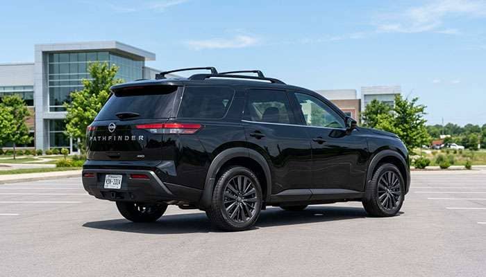 Side view of a black Nissan Pathfinder SUV parked on a paved lot under clear skies