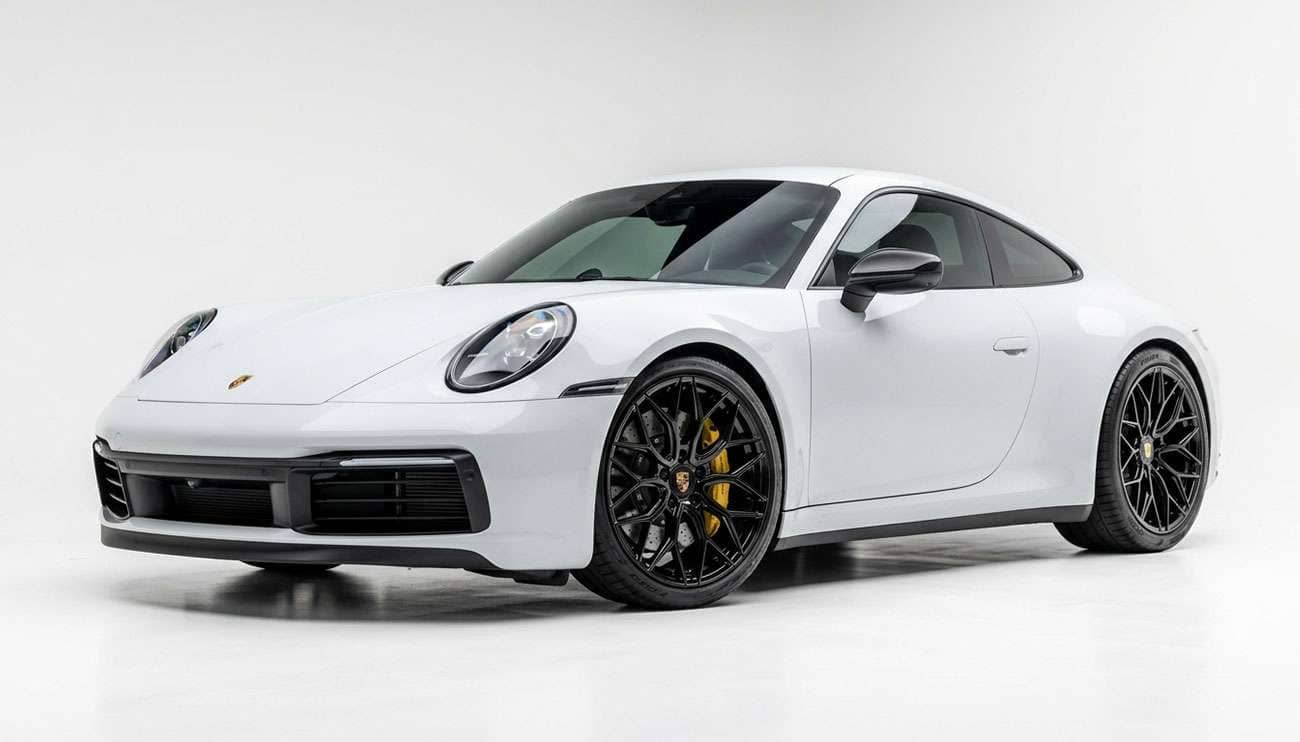 Gloss black aftermarket wheel on a modern sports coupe against a clean white studio backdrop