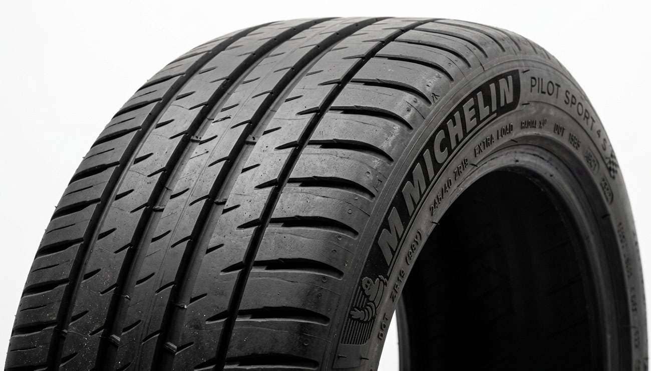 Close-up detail of a black rubber car tire tread and sidewall