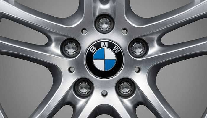 Close-up of a silver BMW wheel showing the bolt pattern and center bore with the BMW logo in the center