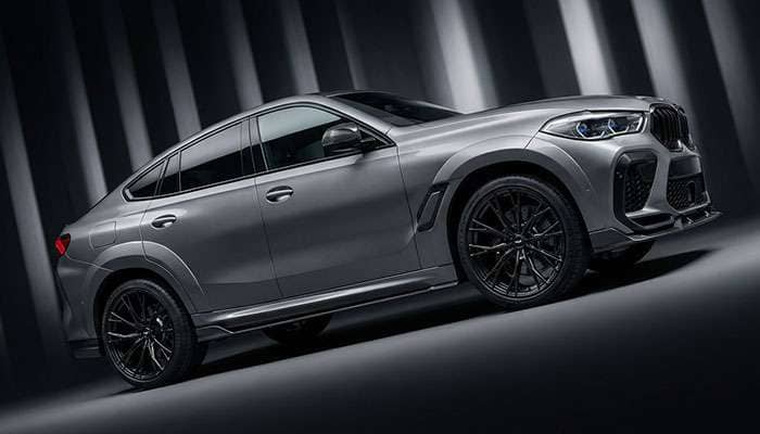 BMW X6M F96 LCI in gray with black forged wheels by Larte Design displayed against a striped black background
