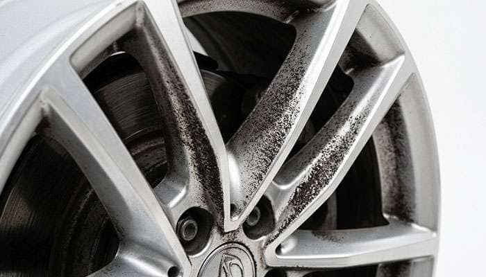 Dark brake dust accumulation visible on the spokes of a silver alloy wheel