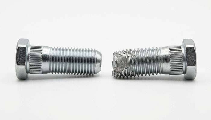 side by side comparison of an intact threaded wheel stud and a snapped wheel stud with sheared torn threads