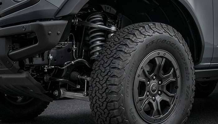 Inside view of a 35-inch all-terrain tire on a Ford Bronco factory 17-inch wheel showing the gap to the upper control arm