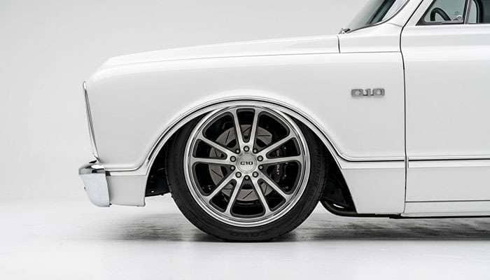 Lowered C10 truck wheel and tire fitment showing stance and fender clearance, studio photo