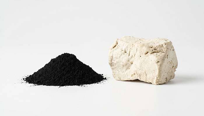 Carbon black powder beside a piece of raw off-white natural rubber