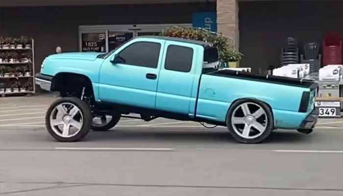 Light blue pickup truck with front lifted significantly higher than the lowered rear, demonstrating the Carolina Squat style