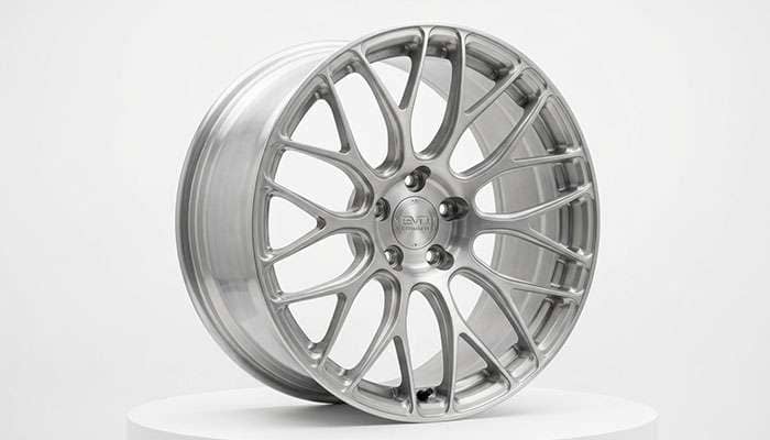 Cast aluminum custom wheel with an intricate multi-spoke design on a white studio backdrop