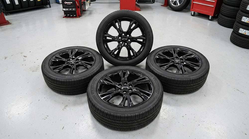 Set of four 20-inch gloss black Chevrolet Blazer OEM wheels and tires, 2019-2021 model years, arranged on a floor