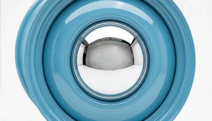 Close-up of a chrome baby moon cap on a body-color smoothie wheel, studio detail photo