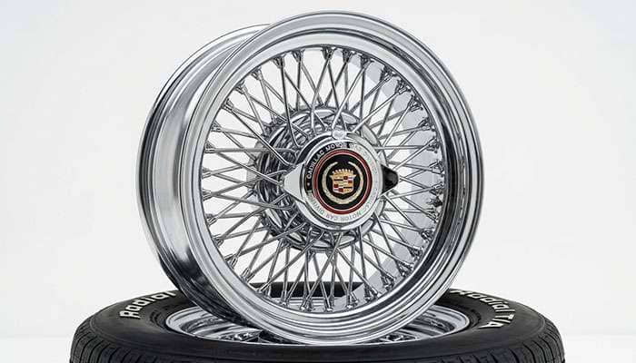 Polished chrome Cadillac-style wire wheel on a clean white studio backdrop