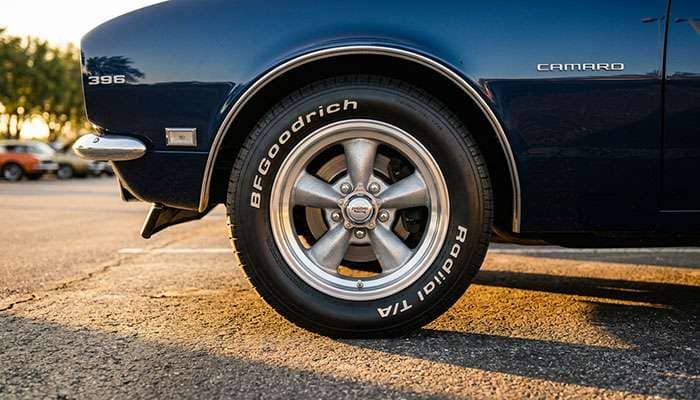 classic American Racing Torq-Thrust style alloy wheel on a 1960s American muscle car showing the iconic five-spoke design