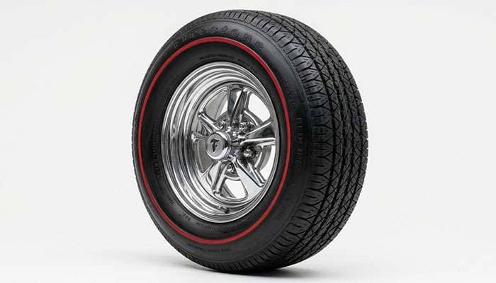 Classic Mopar redline tire mounted on a chrome wheel showing the period-correct red sidewall stripe and tread detail