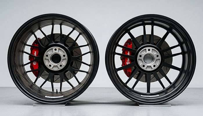 Side-by-side comparison of two aftermarket wheels showing concave spoke design with caliper clearance versus flat shallow spoke design with caliper interference