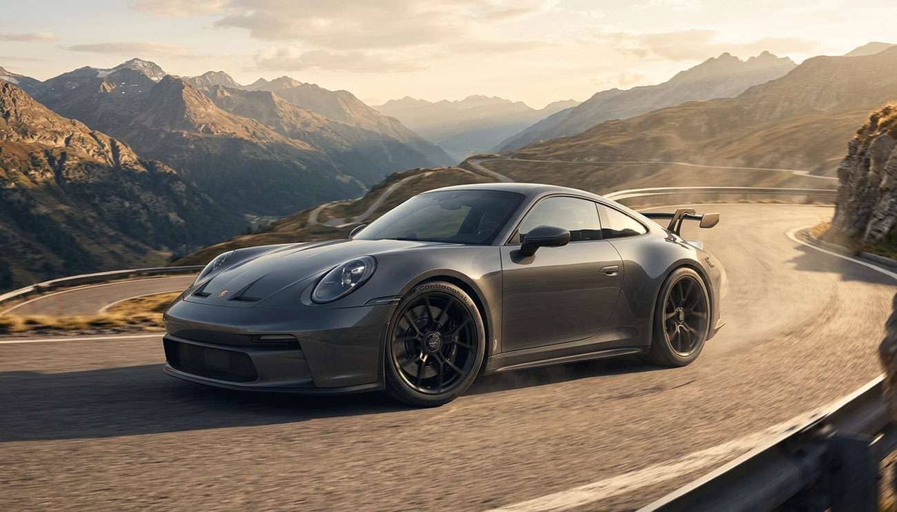 Continental SportContact 7 ultra high performance summer tires on a dark grey sports coupe on a dry mountain road