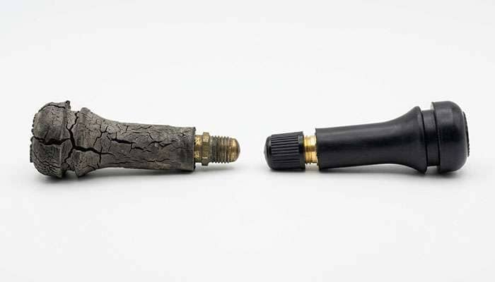 side by side comparison of a cracked dry-rotted rubber valve stem and a new valve stem showing the deterioration at the base