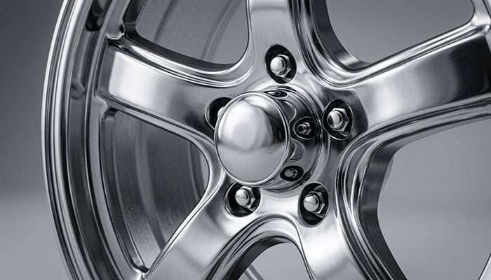 Classic chrome muscle car wheel center cap with five-spoke design detail