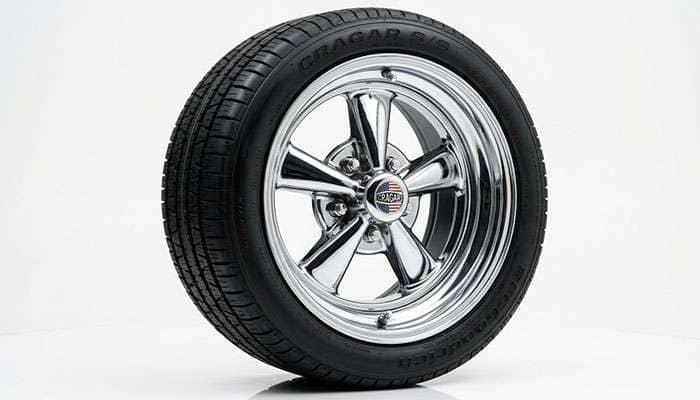 Close-up of a classic chrome five-spoke wheel showing detailed lug nut and lip finish on a vintage truck