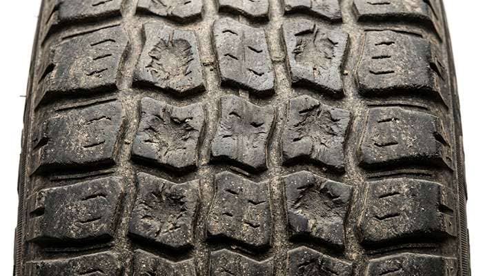 Close-up of scalloped cupping wear across a tire tread