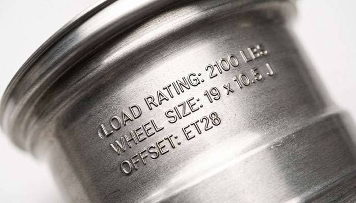 Close-up of a load rating and specification stamp on the inner barrel of a forged custom wheel