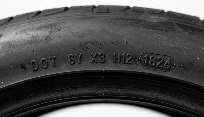 Close-up of DOT date code stamped on car tire sidewall