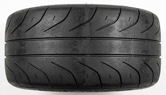 Close-up of a drag radial tire tread showing the soft compound surface and minimal void area engineered for maximum traction