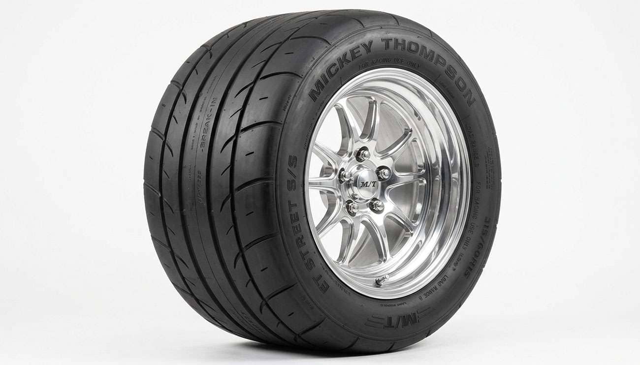 Drag radial tire mounted on a muscle car wheel showing the soft compound tread and reinforced sidewall construction