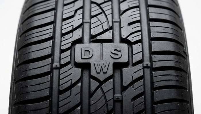 Continental DWS06 Plus DWS tread wear indicators for dry wet and snow on a clean studio backdrop