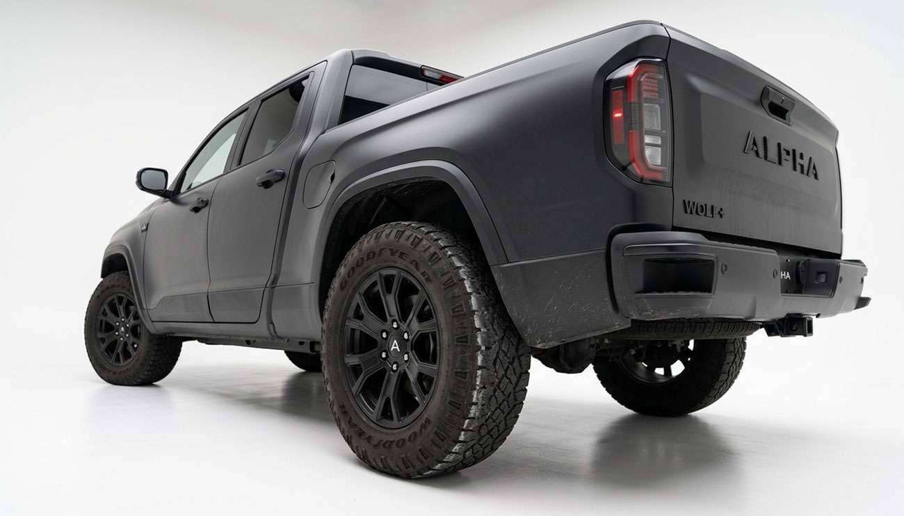 Electric pickup truck rear three-quarter view showing worn tire shoulder on the rear tire