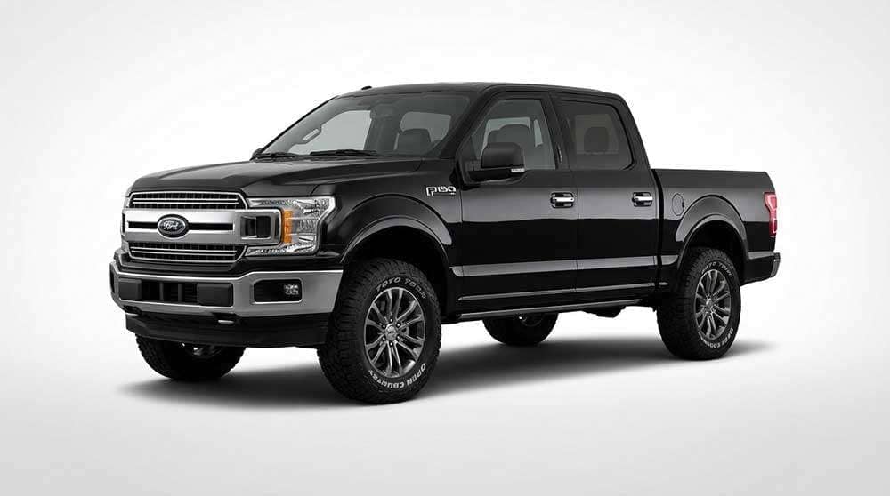 Black Ford F-150 pickup truck with off-road Toyo Open Country tires parked outdoors in daylight