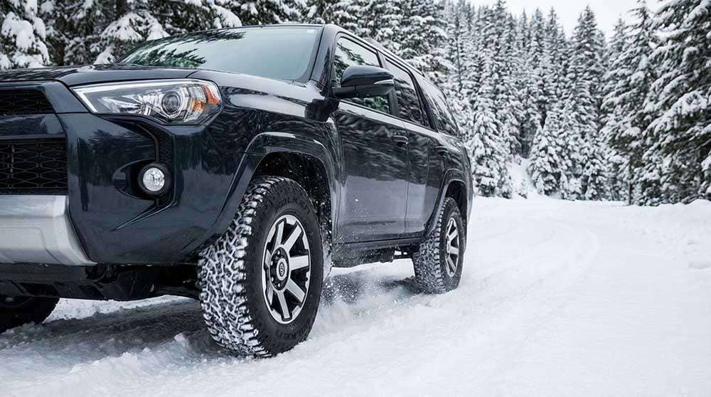 Falken Wildpeak A/T4W tire driving through snow demonstrating winter traction capabilities
