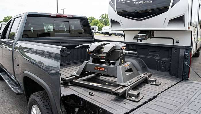 Fifth-wheel hitch mounted in a pickup bed directly above the rear axle with a trailer kingpin engaged