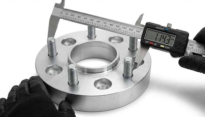 Five-lug wheel adapter showing measurement from center of stud to outside edge on a 1.25 inch thick metal spacer