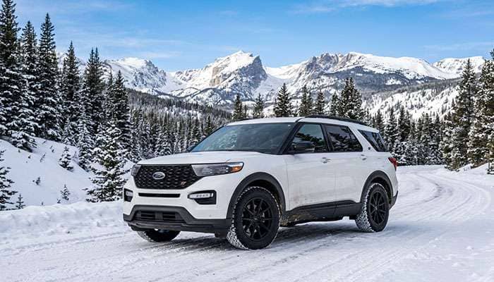 White Ford Explorer ST with black ALPHAequipt Grenade wheels parked on snowy mountain terrain under a clear sky