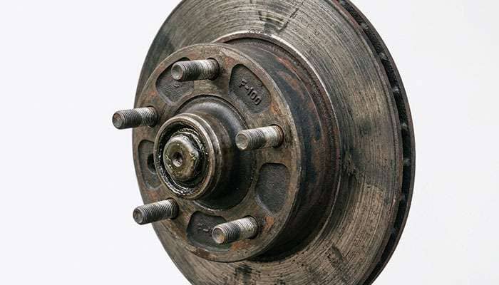 Close-up of a 1970s Ford F-100 front hub showing five lug studs and the center hub pilot