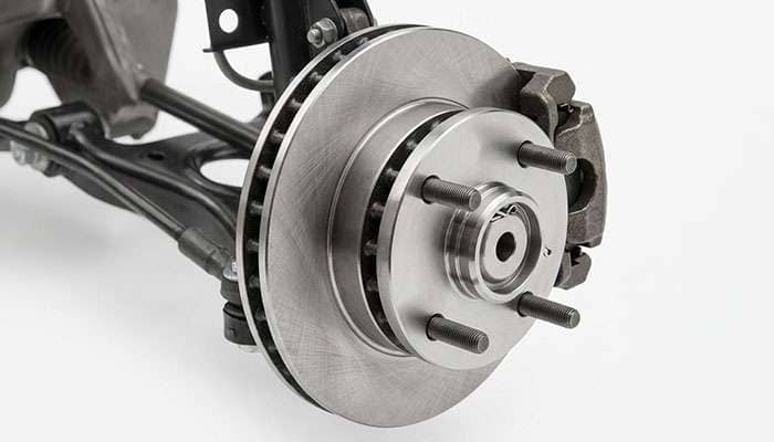 Close-up of a Fox body Mustang 4-lug front hub and rotor with the wheel removed