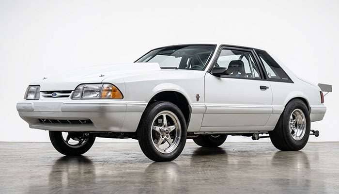 Fox body Mustang drag car with narrow front runner wheels and wide rear drag radials