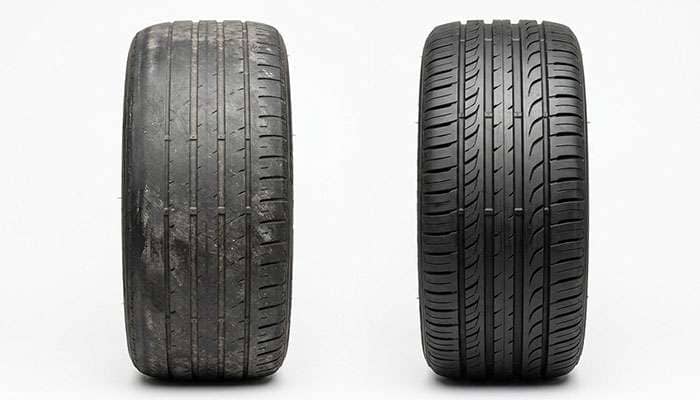 Comparison of a worn front tire with rounded outer shoulders next to a rear tire with deeper even tread