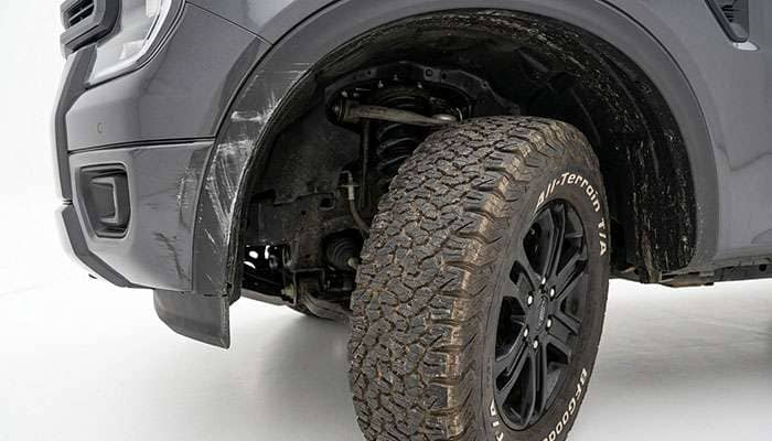 Front fender liner and lower valance area of a midsize pickup truck wheel well showing tire contact wear