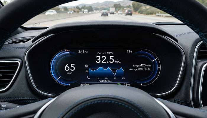 Modern car dashboard displaying fuel economy metrics with digital speedometer and information screen.