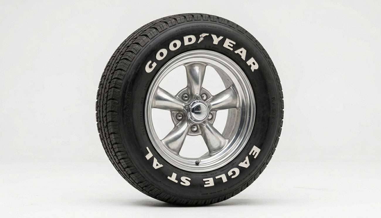 Classic five-spoke muscle car wheel mounted with a raised white letter tire on a clean white studio backdrop
