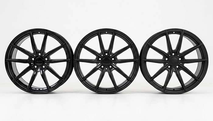 Gloss, satin, and matte black wheels compared side by side on a clean white studio backdrop