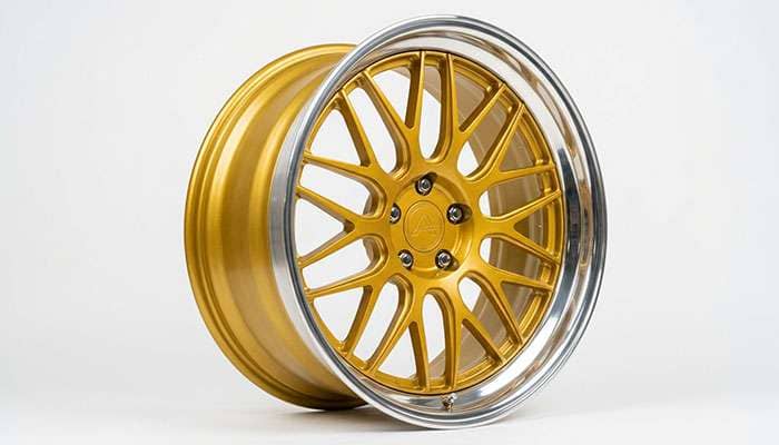 Close-up of a two-tone gold wheel with a machined mirror-cut lip on a white studio backdrop
