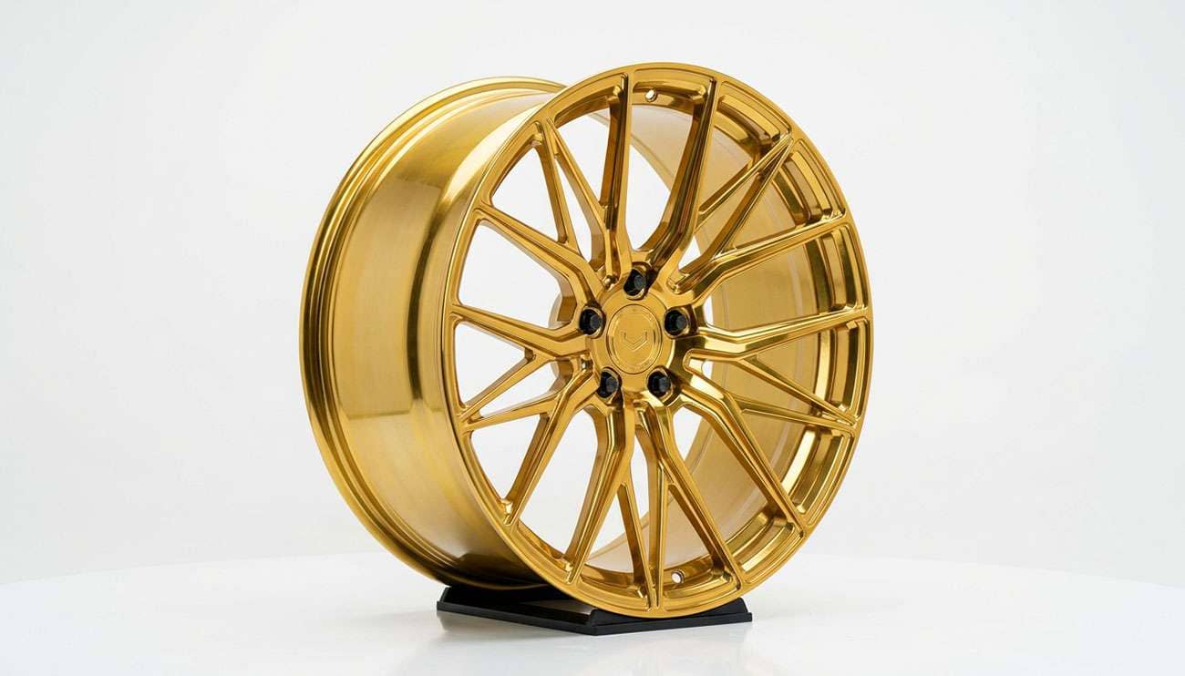 Gloss gold multi-spoke performance alloy wheel on a clean white studio backdrop