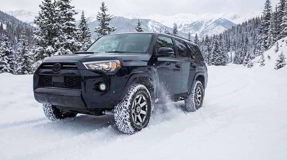 Goodyear Wrangler DuraTrac tires on a vehicle, covered in snow, highlighting their performance in snowy conditions